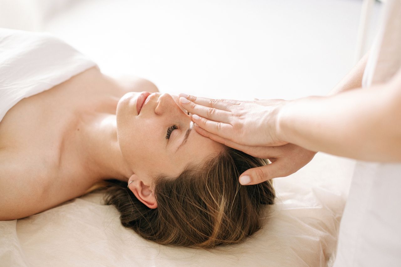 our-story Woman enjoying a peaceful head massage in a serene spa environment.