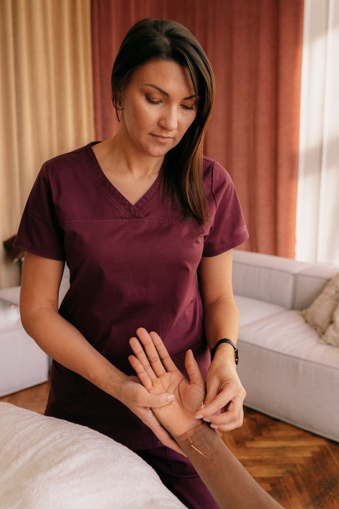 services-01 Acupuncturist applies needles during therapy session for health and wellness indoors.